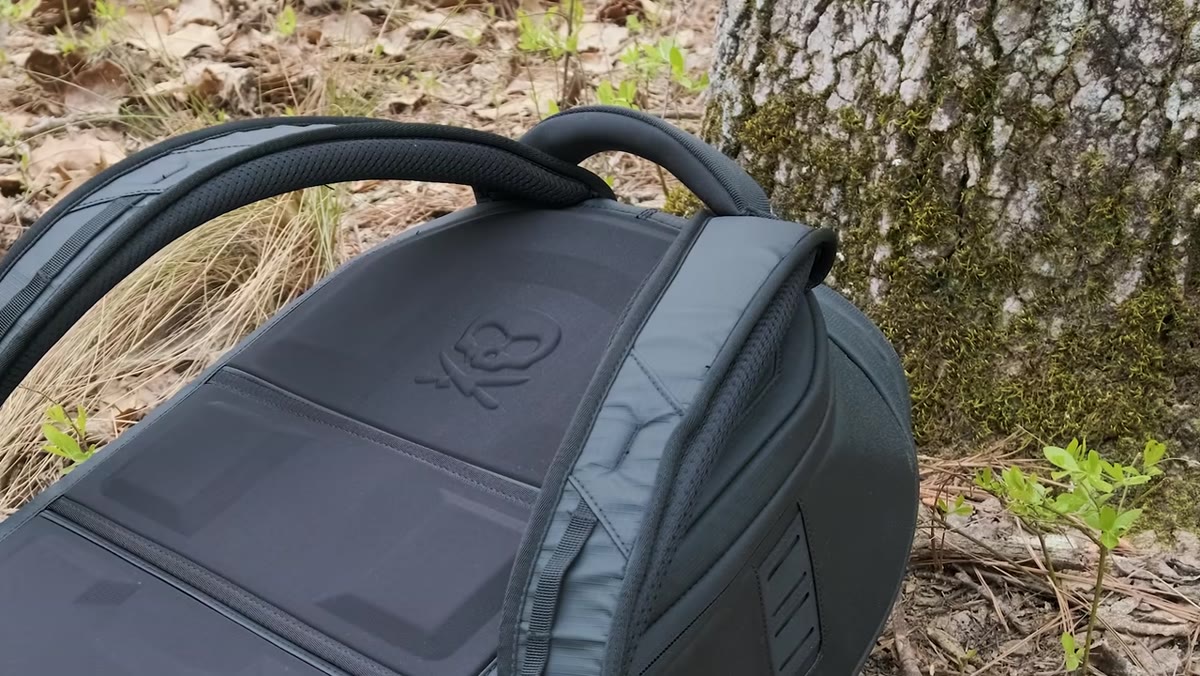 Denney gripping the padded top handle on the bag