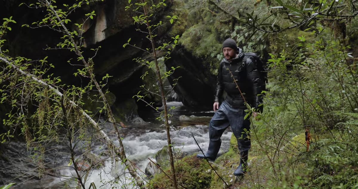 Photographer setting down bag at canyon edge before entering creek