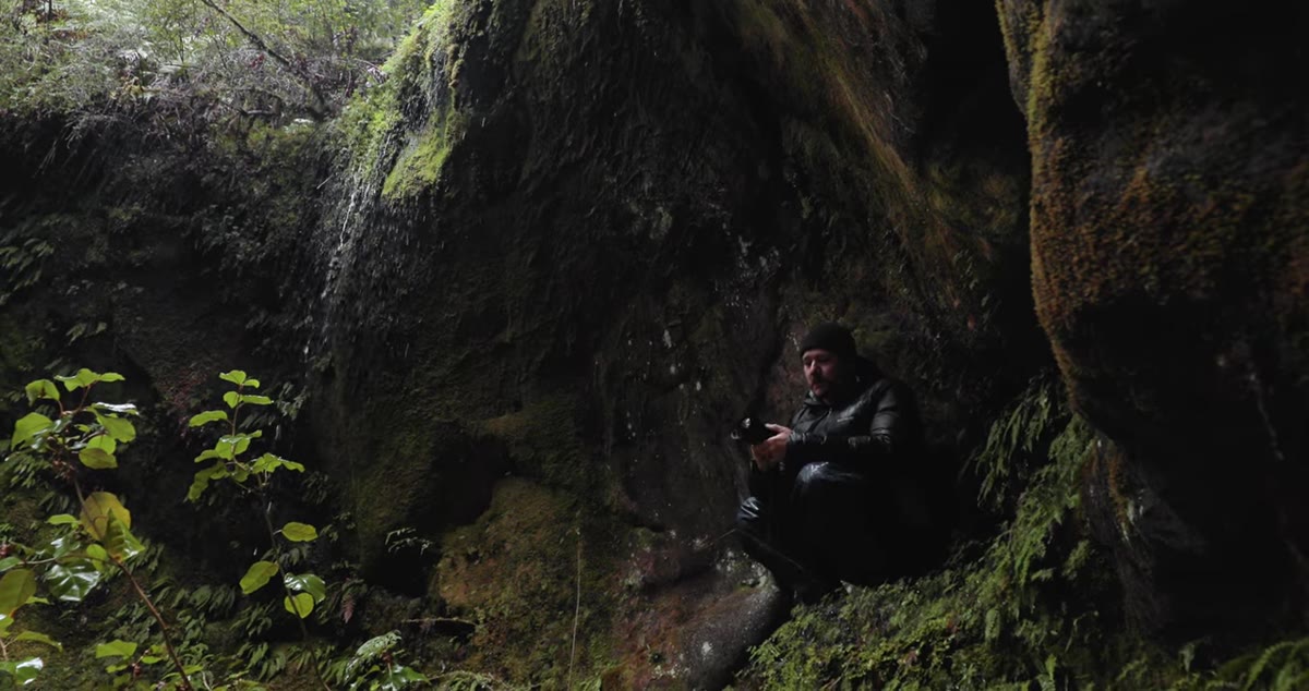Photographer looking up at overhang, evaluating a problematic frame