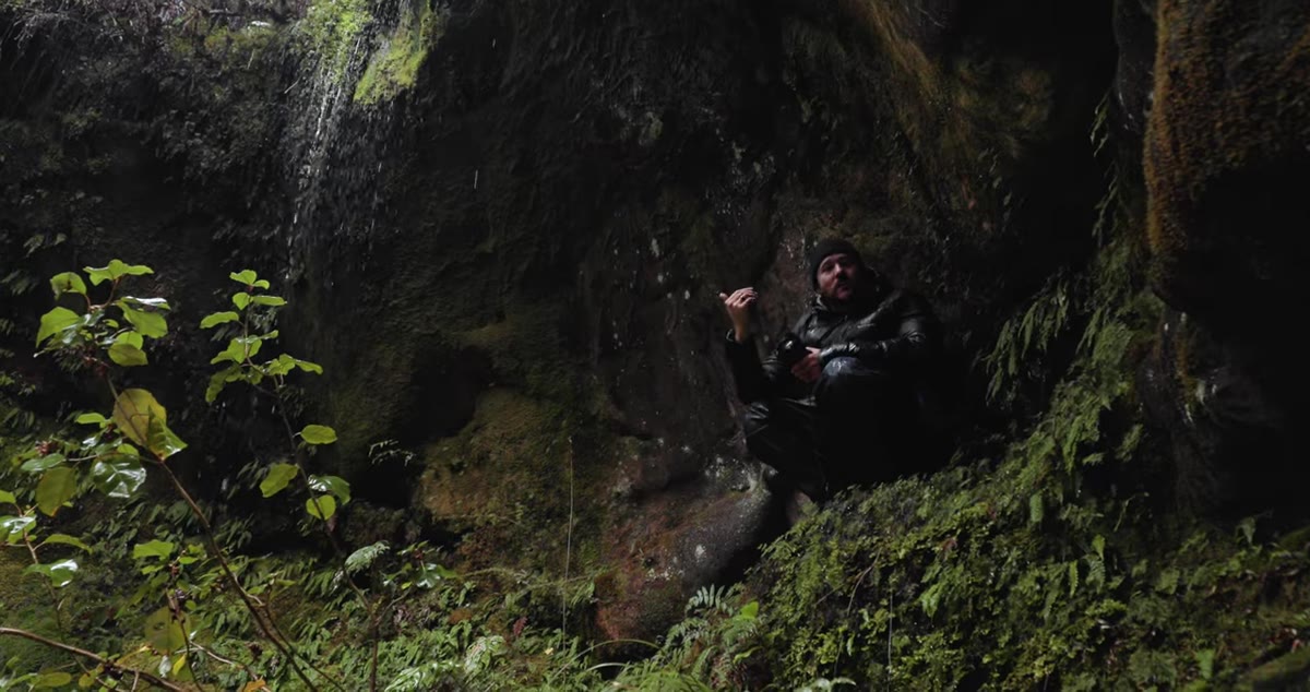 Photographer turning away from main waterfall to assess surrounding scene