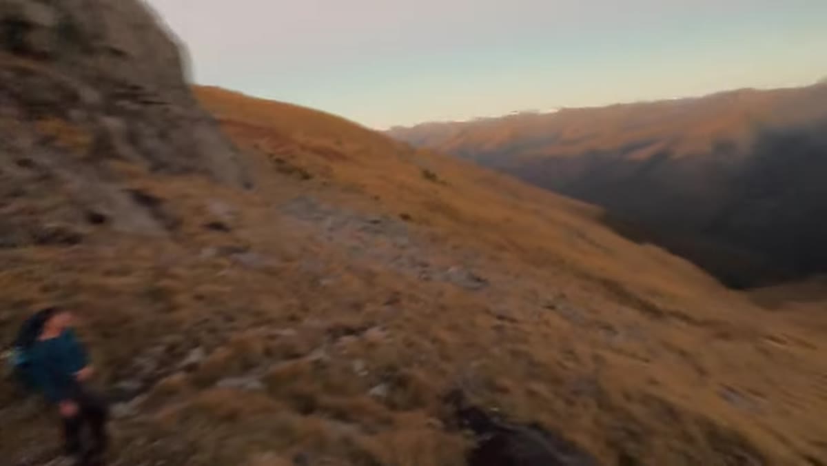 Dawn light spreading across mountain peaks and landscape
