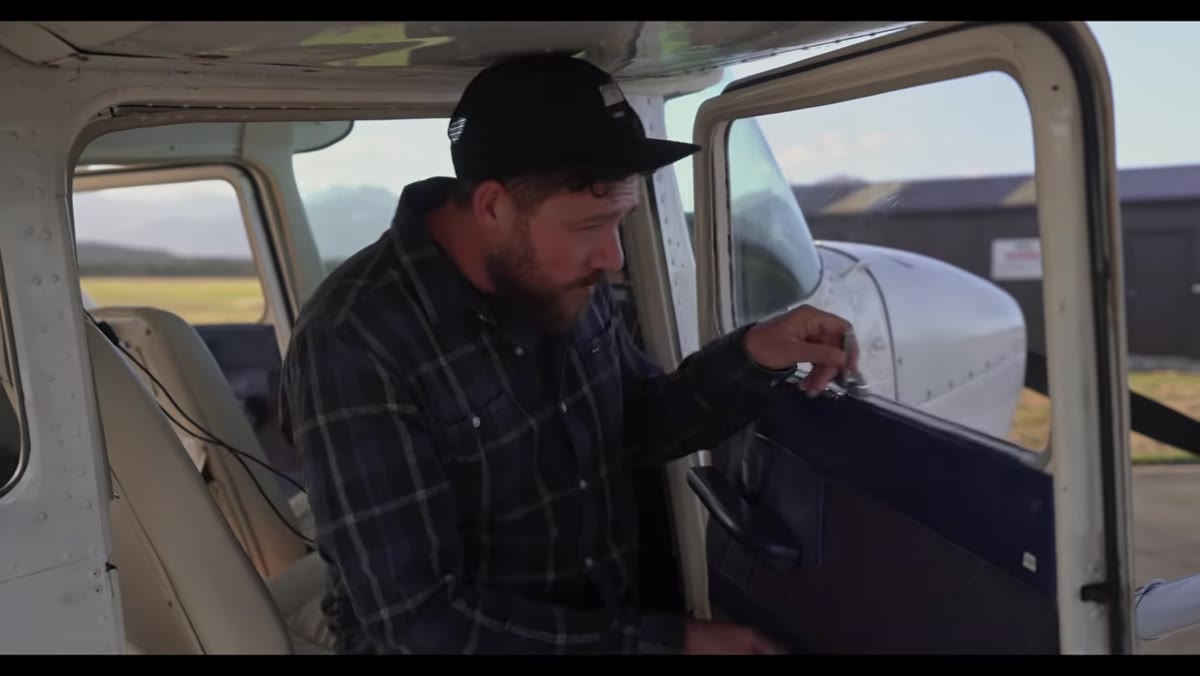 Patino showing the open aircraft window for shooting