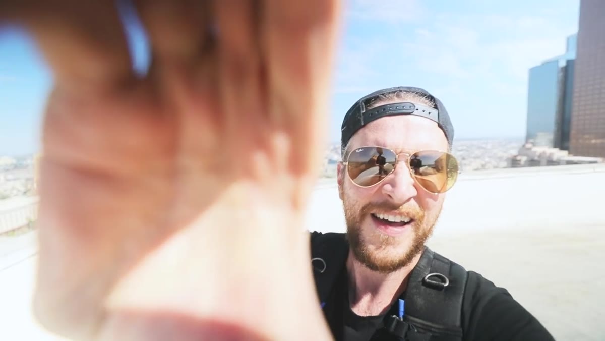 Camera lens being unscrewed to reveal overexposed, washed-out bright sky