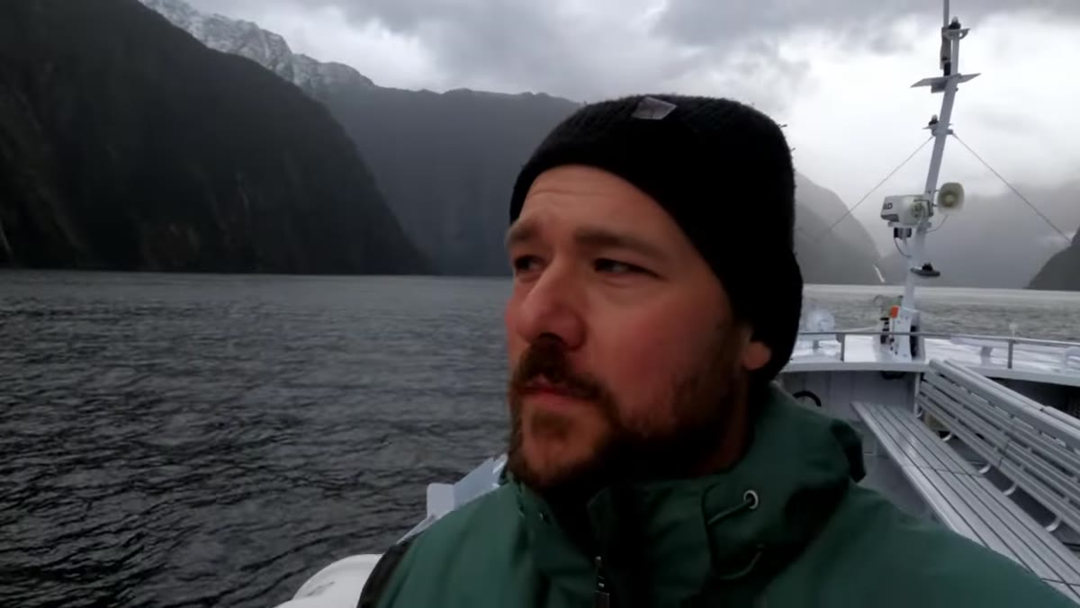 Private charter boat approaching dramatic cliff faces in Milford Sound