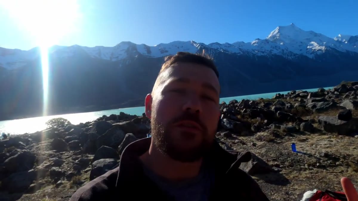 Photographer setting up camp with mountain peaks visible behind