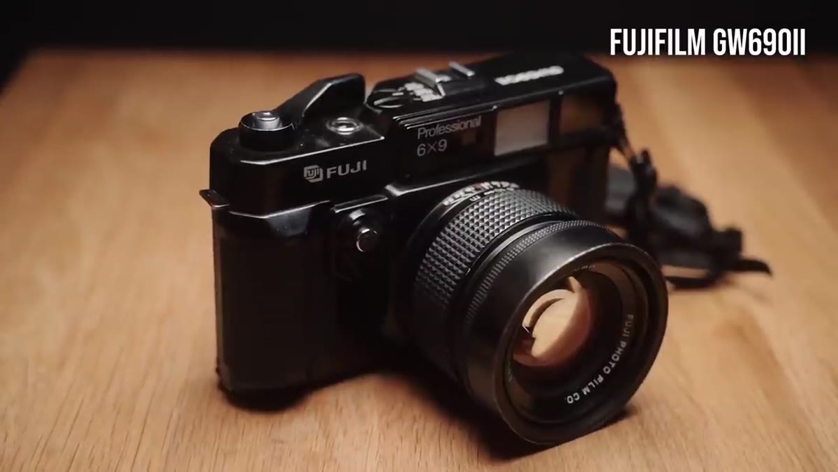 Two film cameras side by side on a surface