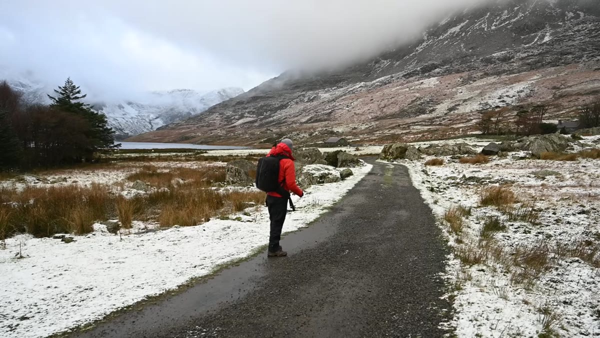 Snowdonia hillside with dramatic cloud break and snow beginning